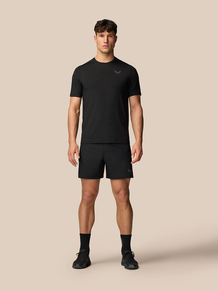 Male model wearing black Apex Training T-Shirt with matching shorts in full-body pose.