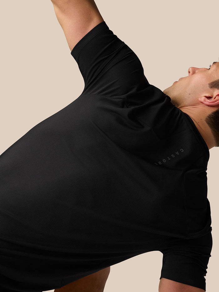 Side view of model in black Apex Training T-Shirt highlighting underarm mesh panels and sleeve shaping