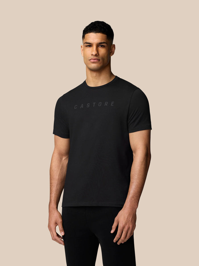 Male model wearing a black Castore graphic T-shirt with crew neck and short sleeves