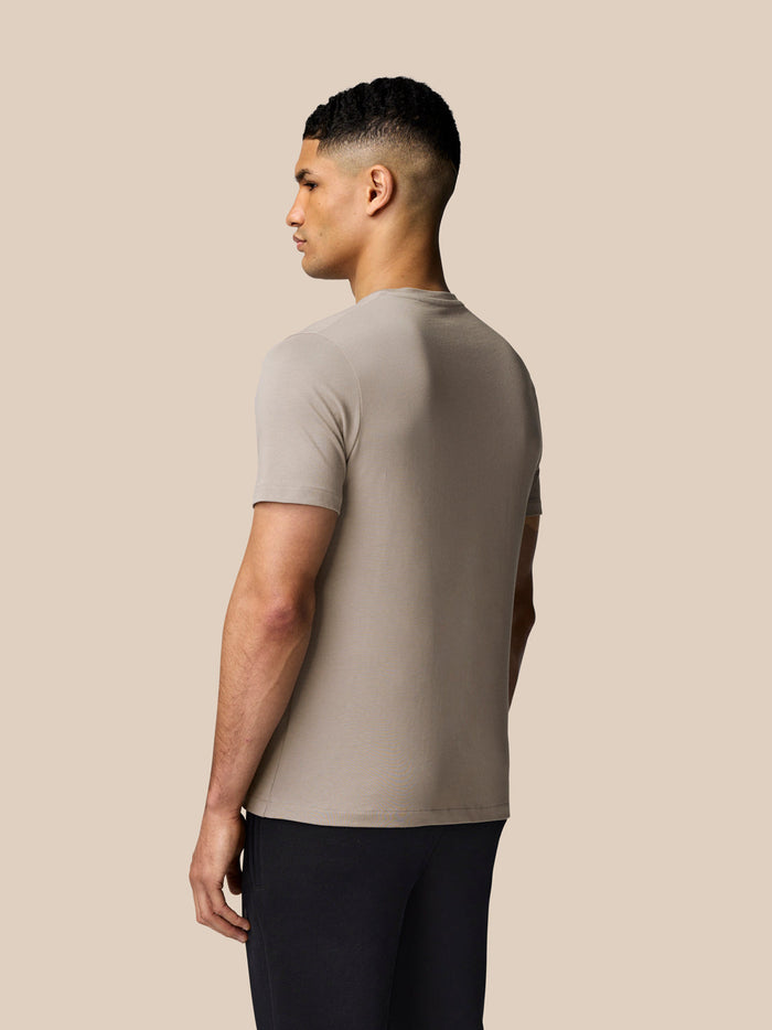 Back view of a man wearing a Rock Grey graphic lifestyle T-shirt with a crew neck