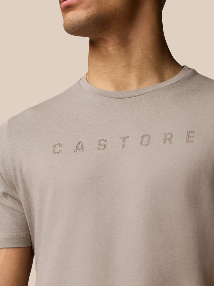 Close-up of a man wearing a Rock Grey Castore graphic T-shirt with the front logo