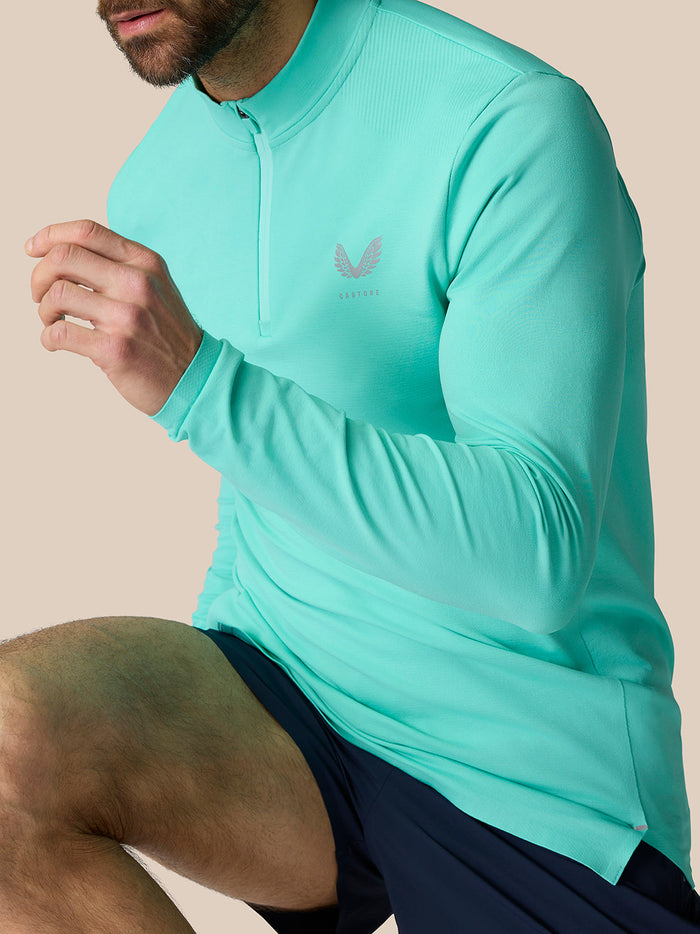 Model wearing light aqua Zone Training 1/4 Zip Top with high neck and chest logo