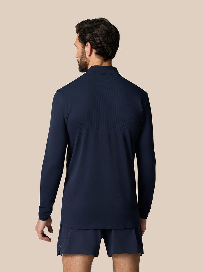 Back view of navy Zone Training 1/4 Zip Top on a man, featuring engineered knit panels and a dropped hem.