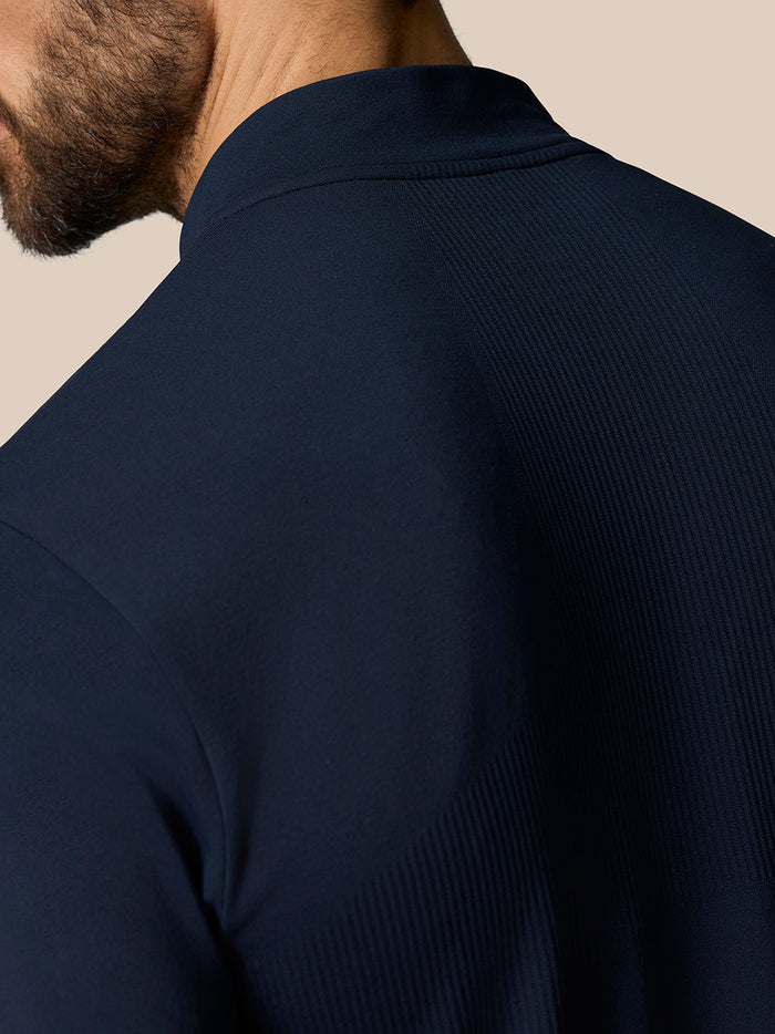 Shoulder close-up of navy Zone Training top showing ribbed knit panel and smooth fabric.