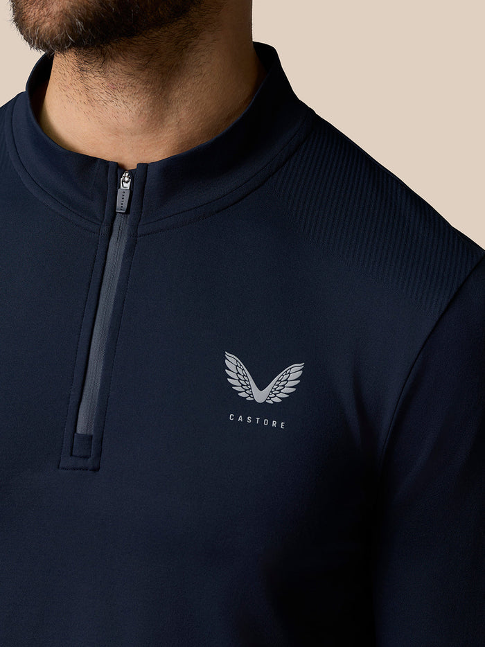 Close-up of navy Zone Training 1/4 Zip Top with chest Castore logo and short zipper detail.