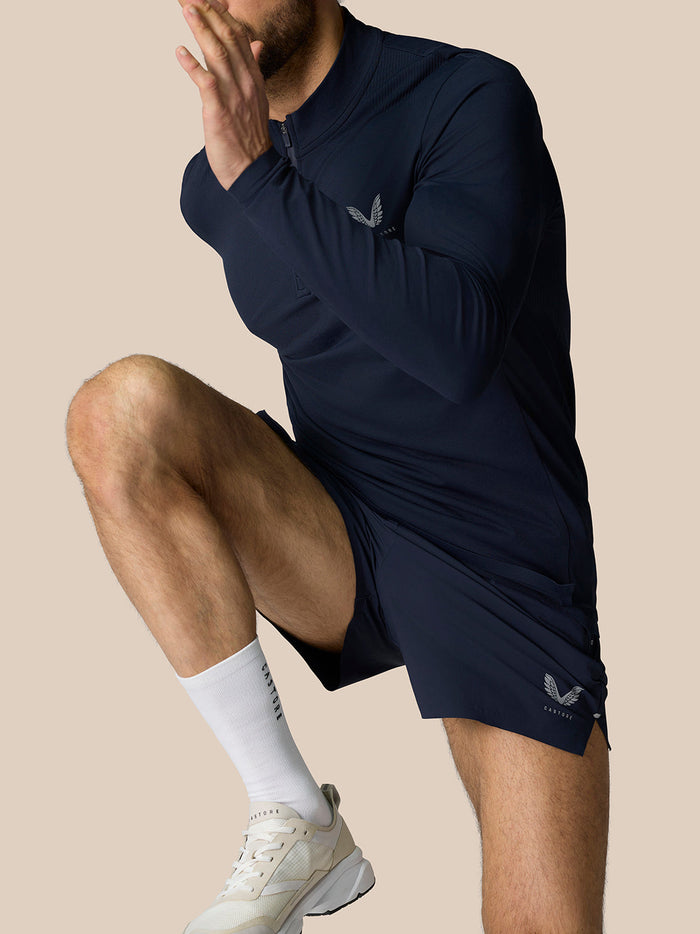 Front view of Zone Training 1/4 Zip Top in Midnight Navy worn by a model; high neck with a quarter zip against a beige backdrop.