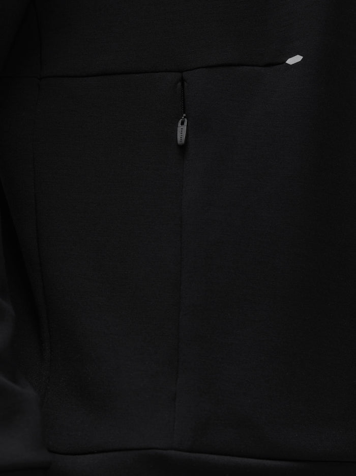 Close up of the back area of a black crew neck travel lifestyle sweatshirt showing a centered zipper detail