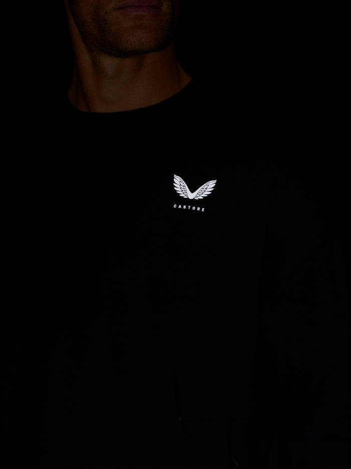 Model wearing black Castore Travel Lifestyle Sweatshirt with white wing logo on chest