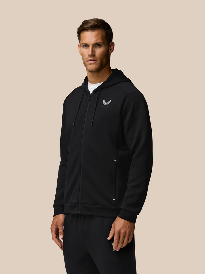 Black Travel Zip Hoodie with a white left chest logo worn by a model