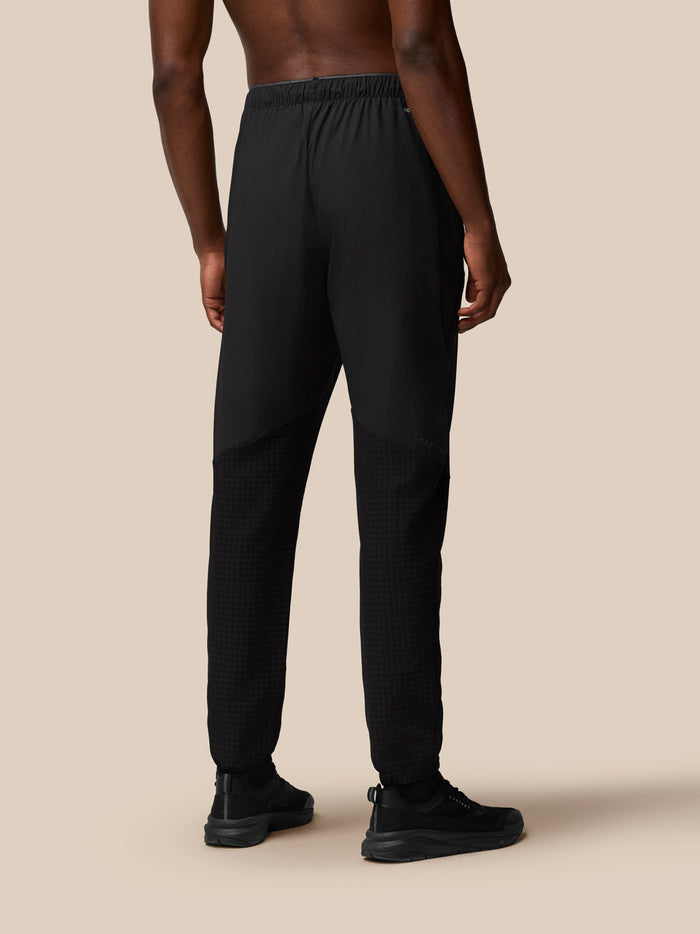Back view of a man wearing black Flex Winterised Woven Joggers with textured lower leg panels