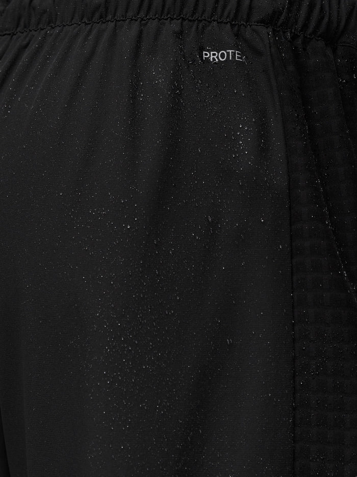 Close-up of black Flex Winterised Joggers fabric with ProTek logo and water droplets
