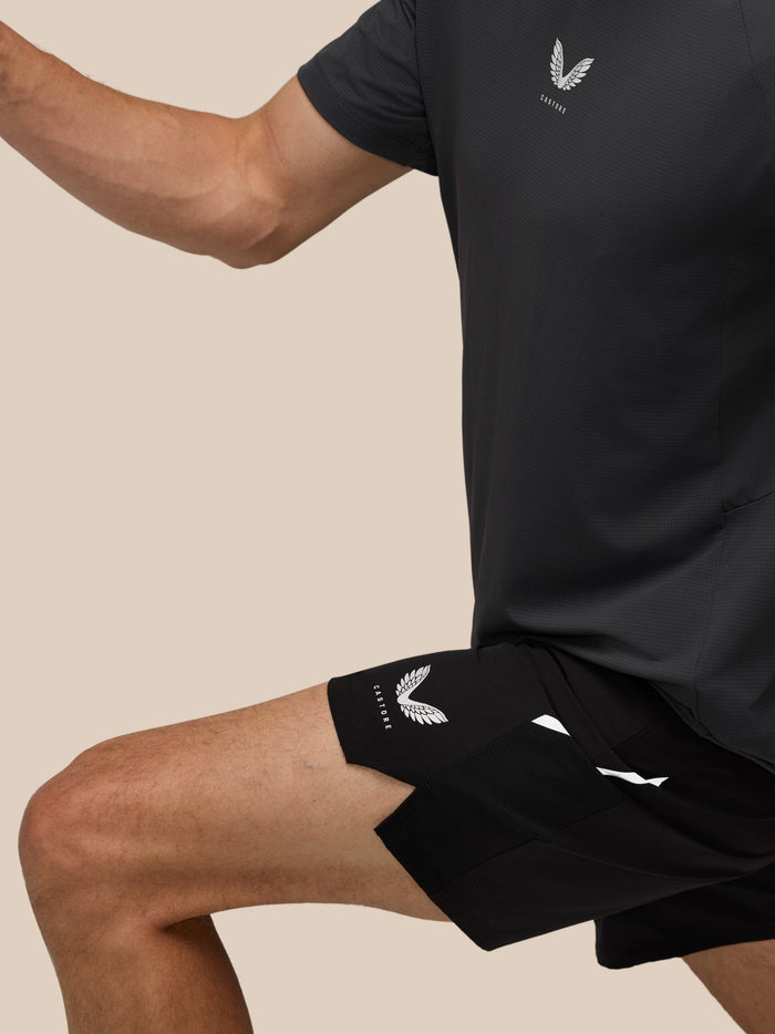 Castore logo on the chest of a dark athletic shirt worn by a man