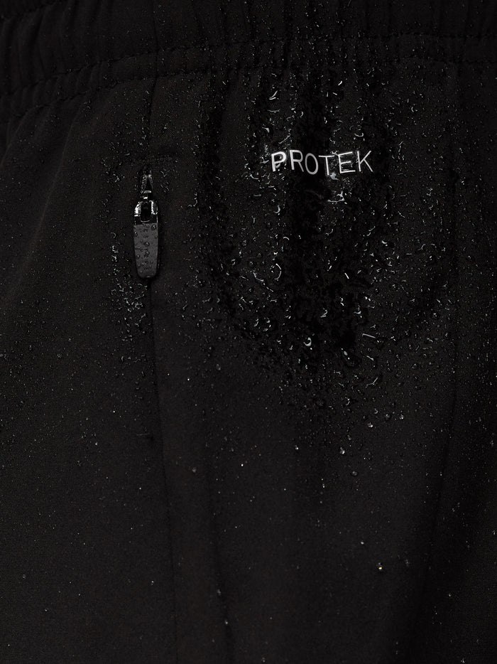 Close-up of black Apex shorts fabric with a ProTek zipper pocket and water droplets