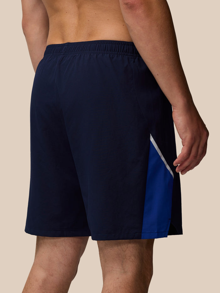 Back view of navy Apex shorts with a blue side panel and white trim