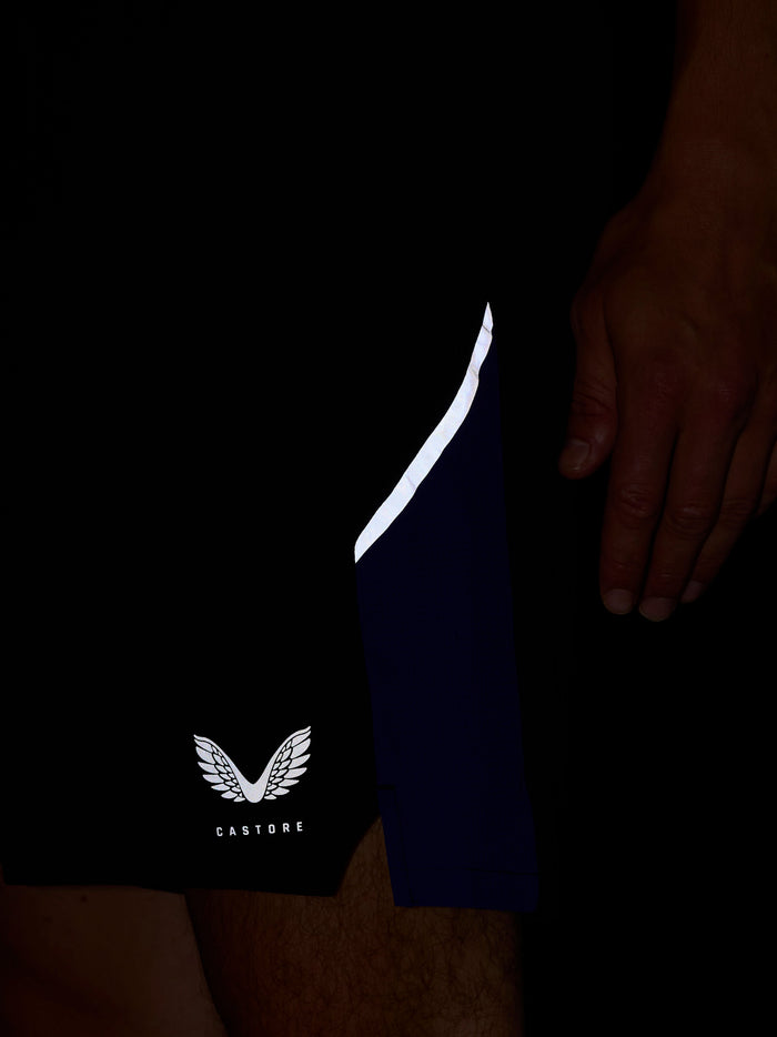 Close up of navy shorts showing a white curved side stripe and Castore wing logo near the hem