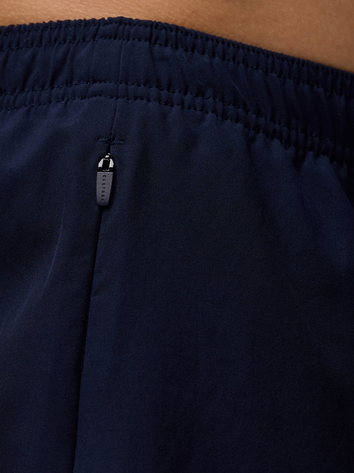 Close up of navy Apex shorts waistband showing a zipped pocket and Castore branded zipper.