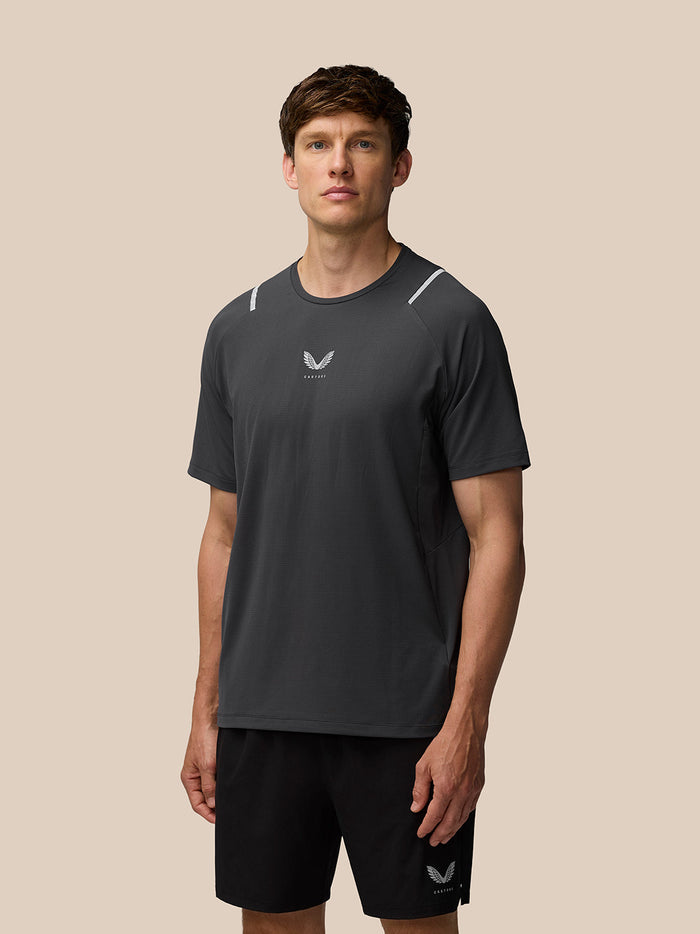 Angled rear view of Apex Short Sleeve T Shirt Gunmetal showing knit texture and Castore logo at back hem