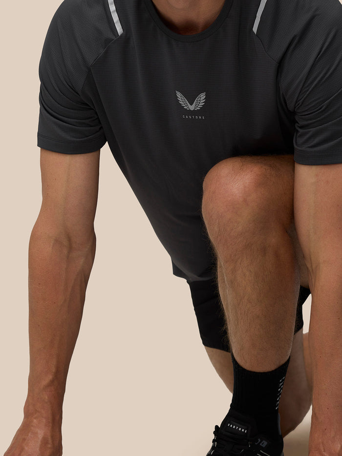 Male model wearing black Apex Training T Shirt with Castore logo on the chest and reflective shoulder strips