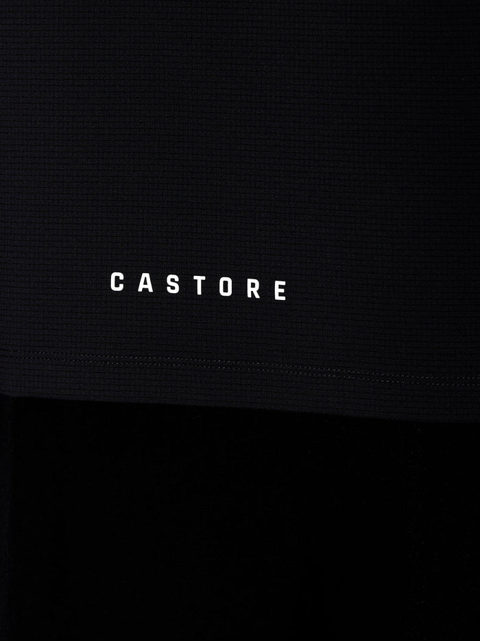 Close-up of Castore logo and wordmark on the black Apex T shirt fabric