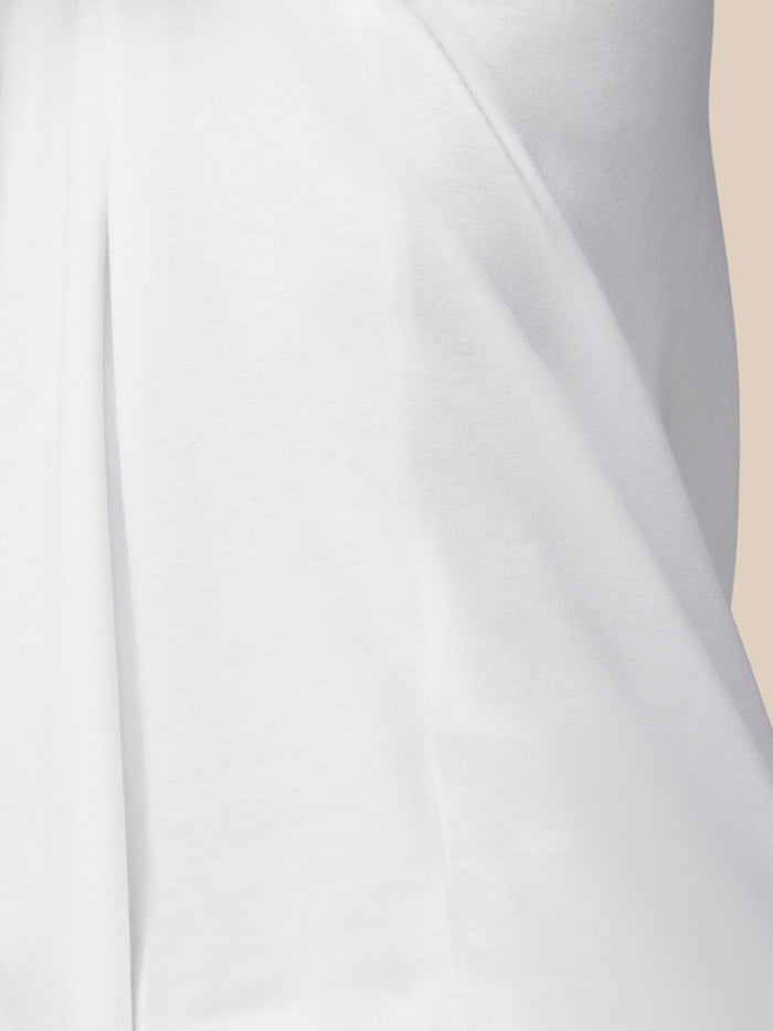 Close-up of white cotton knit fabric and side seam detail.