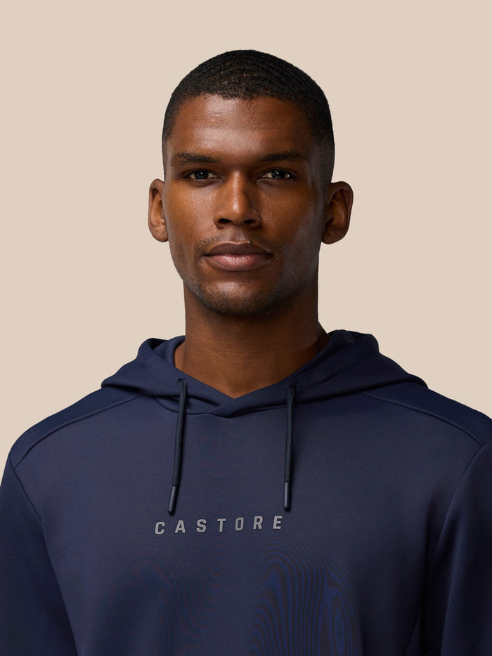 Navy Castore hoodie worn by model with wordmark at center chest