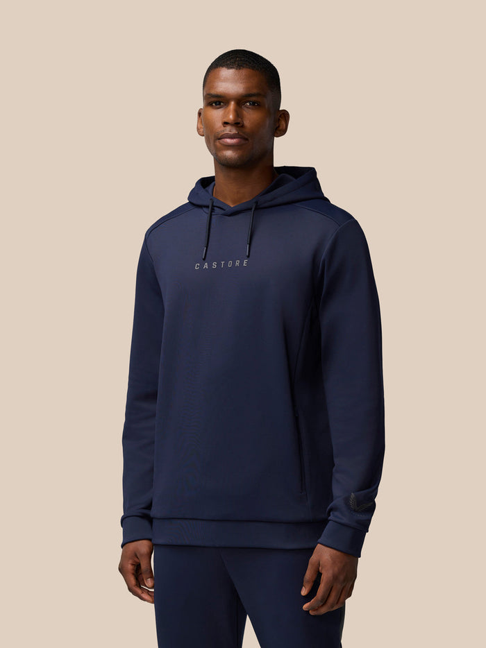 Male model wearing navy Castore Flex Thermo hoodie with drawstrings and a subtle chest logo