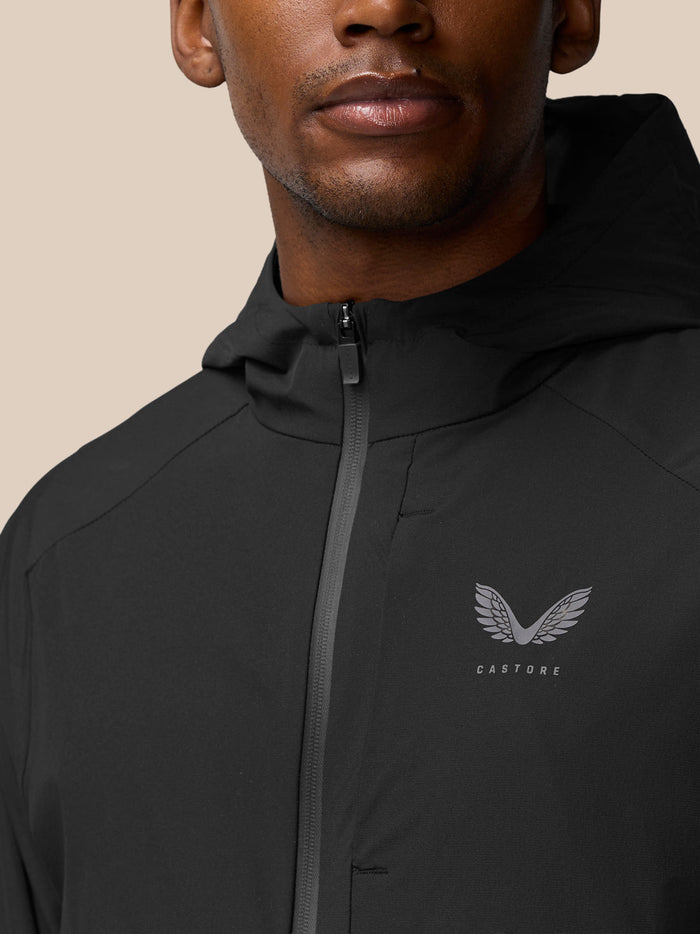 Close-up of the black Flex Winterised Woven Jacket showing the zipper and left chest Castore logo.