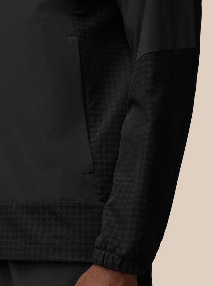 Close-up of black Flex Winterised Woven Jacket chest area with vertical zipper and subtle panel texture.