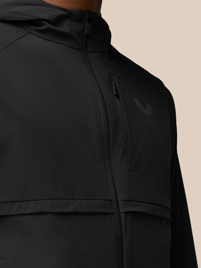 Close-up of black jacket chest featuring a vertical zipper pocket and Castore logo.