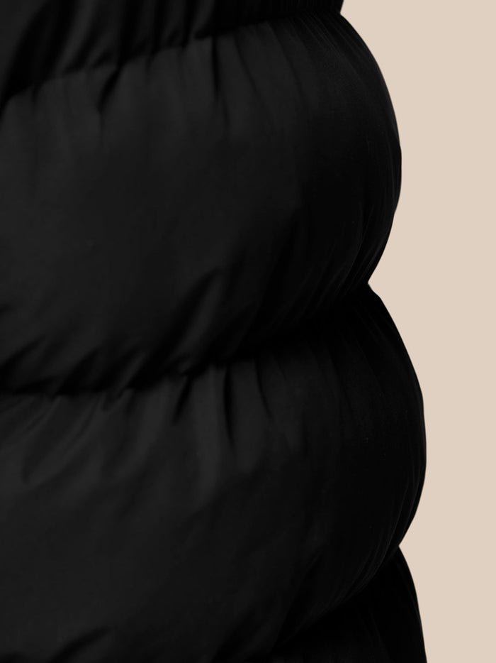 Close-up of black Puffer Gilet fabric showing front zip and quilted panels
