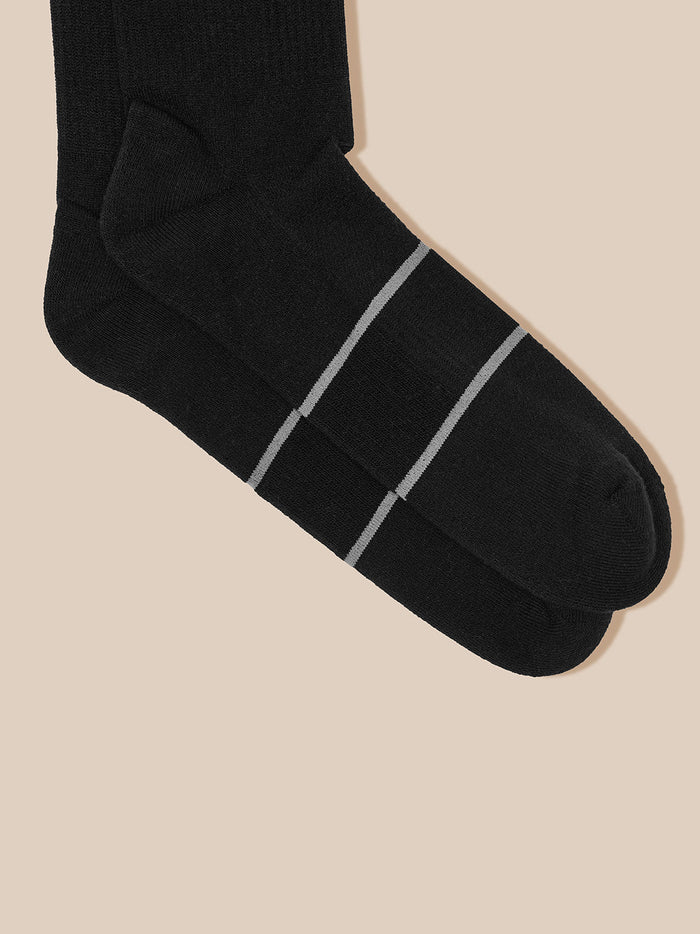 Close-up of black Castore sock toe with two light gray stripes across the midfoot.