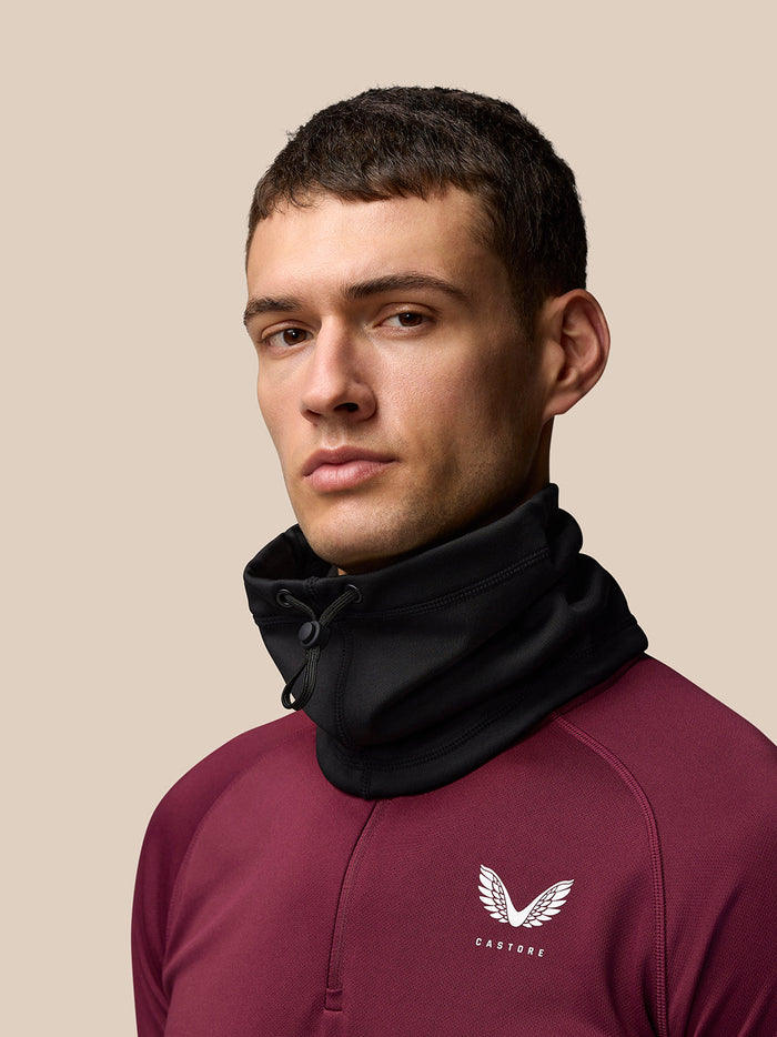 Male model wearing a black core snood around the neck with a drawstring closure