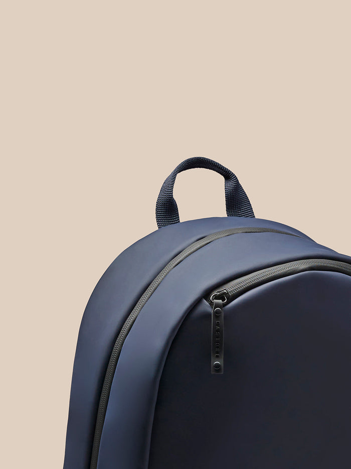 Close-up of navy backpack back showing breathable mesh panel and padded shoulder straps
