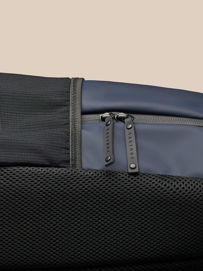 Zipper detail of navy backpack with Castore branded pulls and mesh fabric