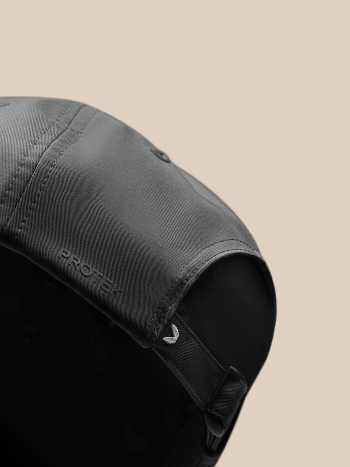 Close up of charcoal nylon cap highlighting back strap and embossed Castore branding.