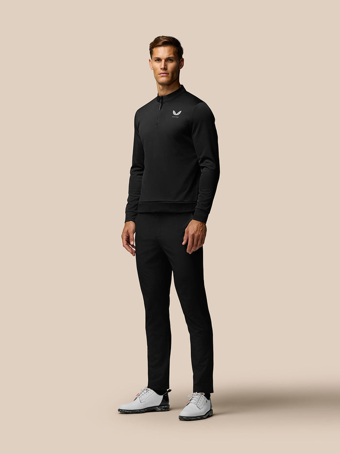 Front view of a male model wearing black Castore Club Golf Trousers and matching golf apparel