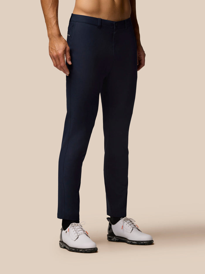 Front view of a man wearing midnight navy Golf Club Trousers 32 inch leg with white shoes