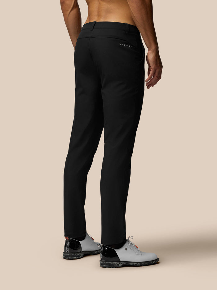 Back view of black Golf Club Trousers 32 on a model, showing welt back pockets and Castore branding
