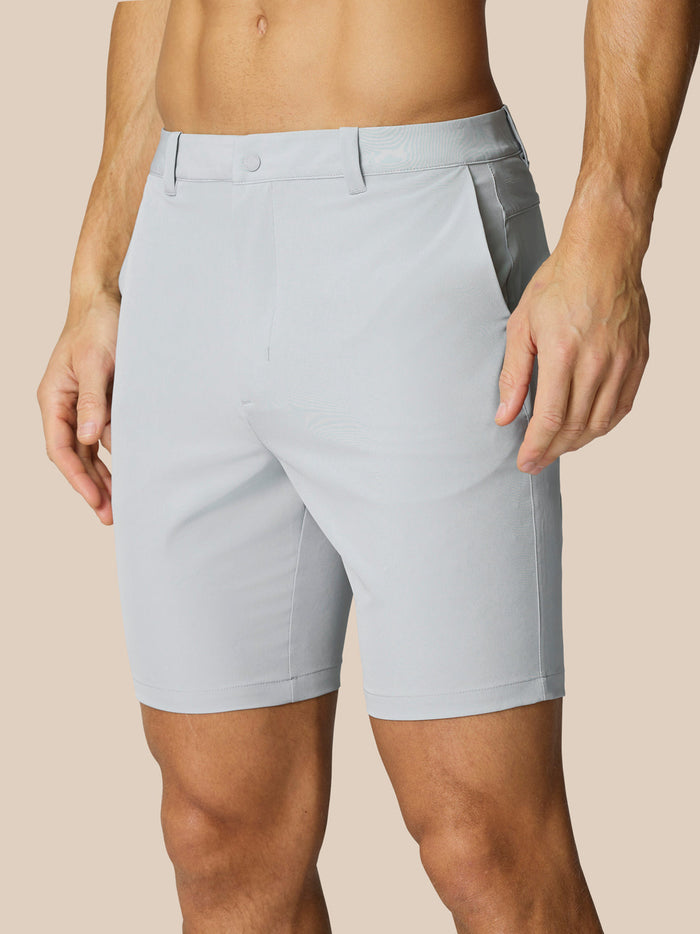 Light grey golf shorts with belt loops worn by a model on a neutral backdrop