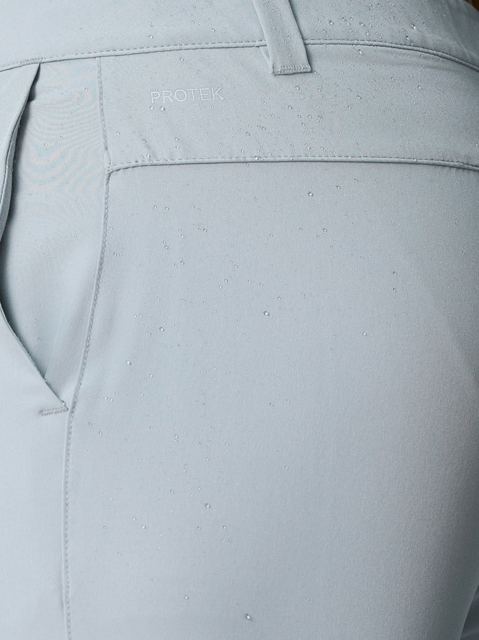 Close up of light grey golf shorts showing ProTek water-resistant fabric and logo on the waistband