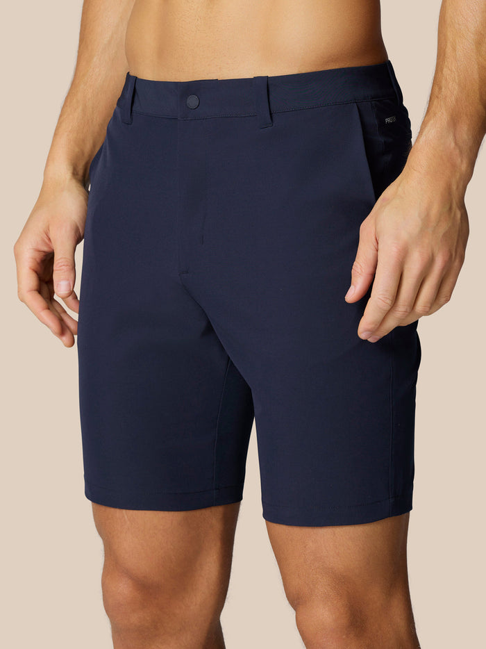 Navy golf shorts shown from the side/back with belt loops and back pocket; Castore branding on right thigh and right rear