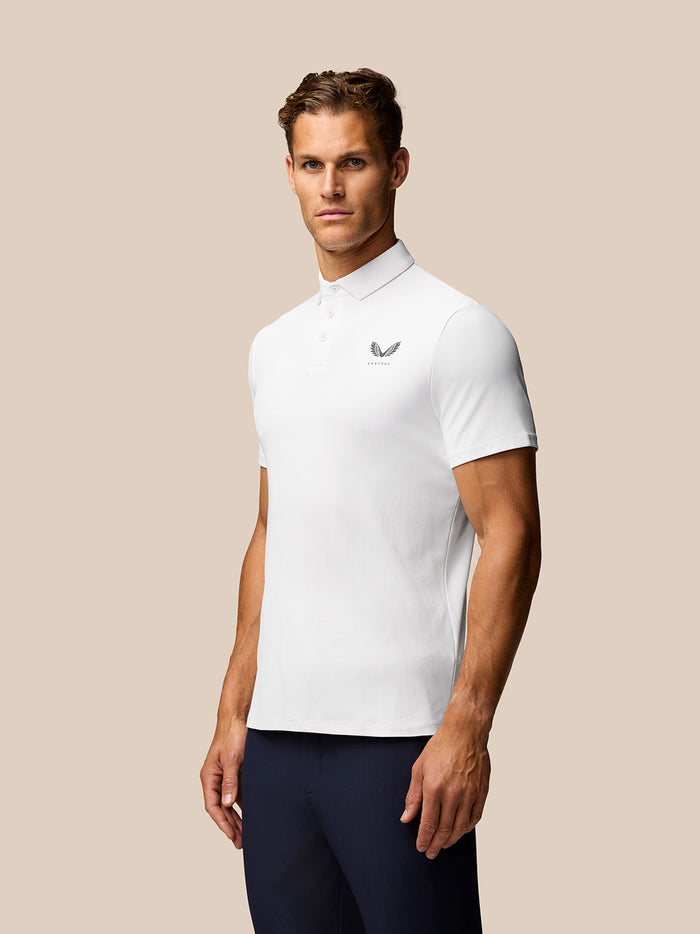Male model wearing white Golf Club Essential Polo with polo collar and short sleeves.