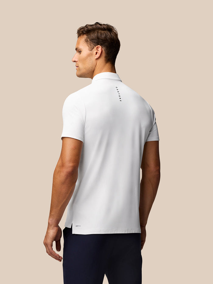 Back view of white Golf Club Essential Polo on a male model with Castore branding along the upper back.
