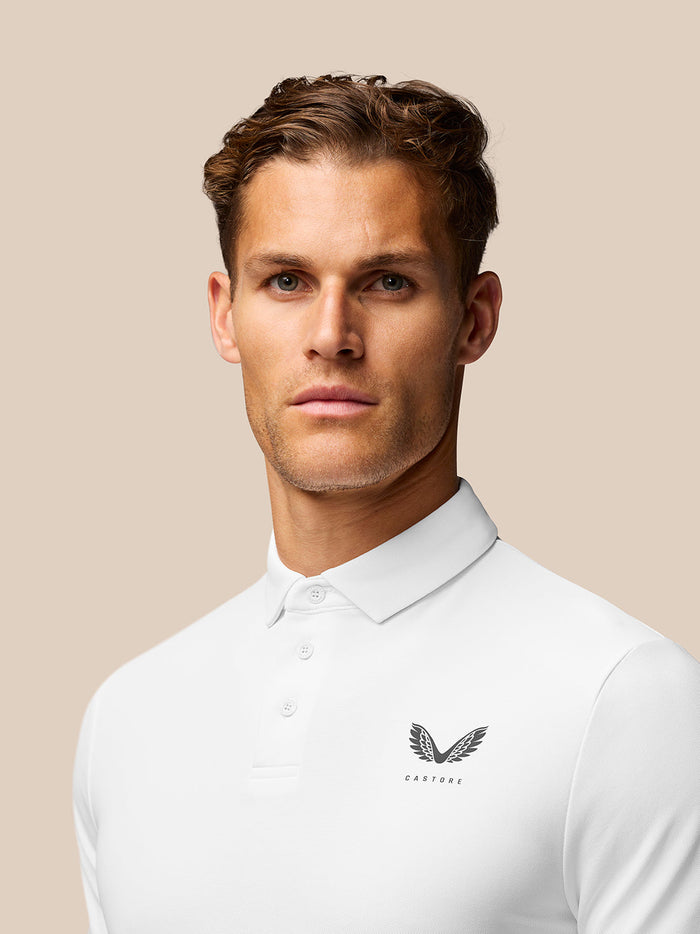 Man wearing a white golf polo with Castore logo on the chest