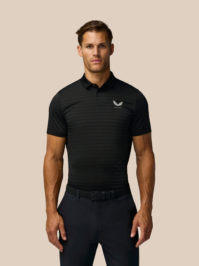 Male model wearing black Pinnacle Pique Stripe Polo with polo collar and button closure