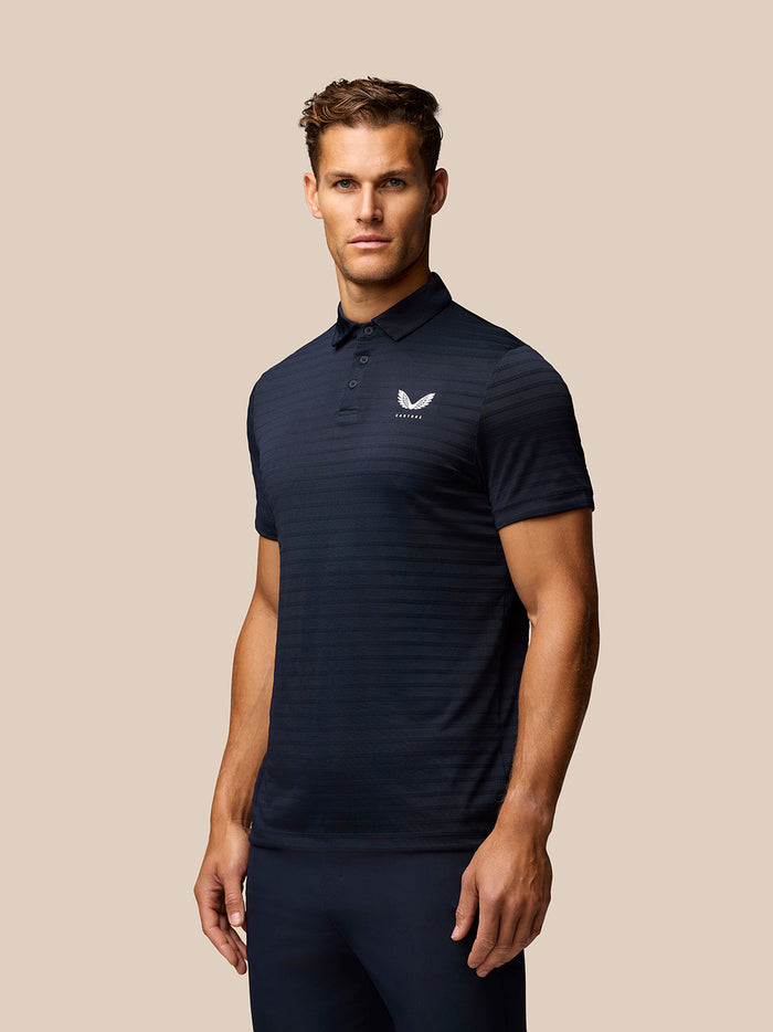 Male model in navy Pinnacle Pique Stripe Polo front view with Castore logo on left chest and subtle stripe pattern