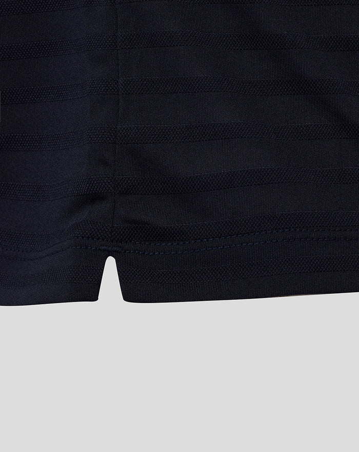 Close up of navy golf polo fabric with textured pique stripes and hem notch detail