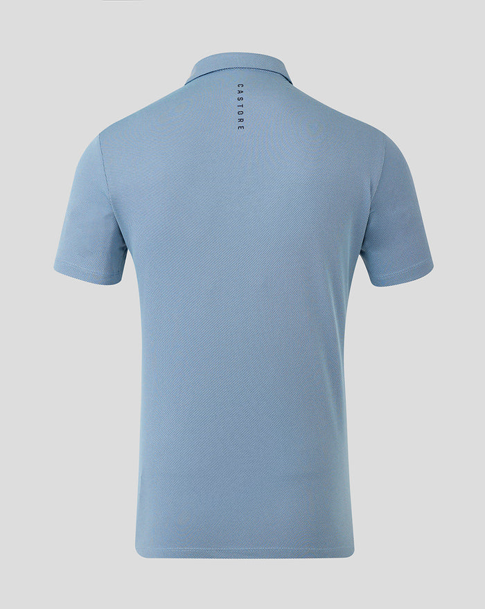 Back view of light blue CASTORE engineered knit golf polo with vertical branding along the upper back