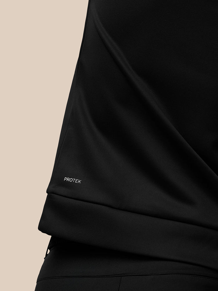Detail of black Protek fabric showing PROTEK branding on the sleeve hem.