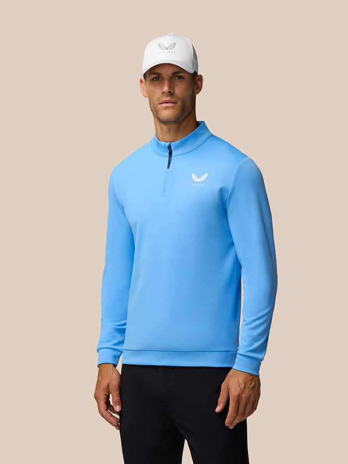 Model wearing Golf Club Classic Quarter Zip Top in Cool Blue with funnel collar and branded zip pull.